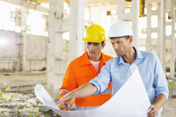 Male Architects Discussing Blueprint Construction Site — Stock Photo, Image