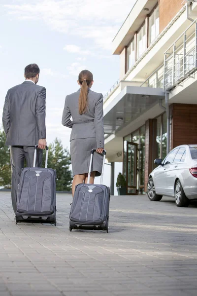 Rückansicht Von Geschäftsleuten Die Mit Gepäck Vor Dem Hotel Spazieren — Stockfoto