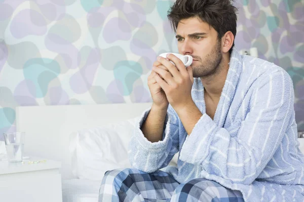 Uomo Malato Bere Caffè Mentre Seduto Sul Letto Casa — Foto Stock