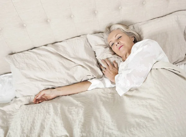 ベッドで寝ている年配の女性 — ストック写真