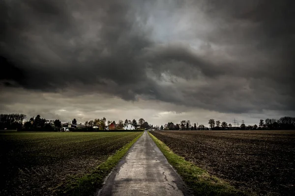 Nfeldweg Mit Häusern Extremer Fluchtpunktperspektive Vor Dramatischem Himmel — Stockfoto