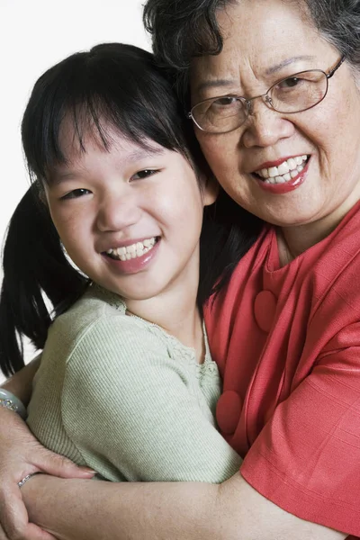 Asian grandmother and granddaughter hugging