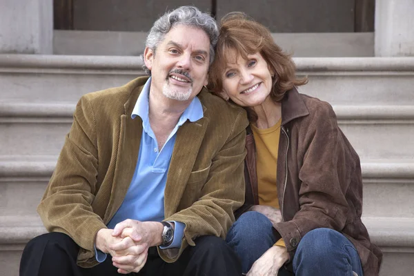 Caucasian couple sitting on front stoop