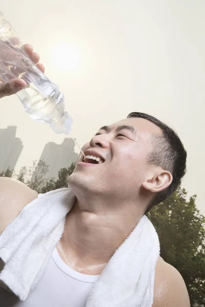 Chinese man drinking water after exercise