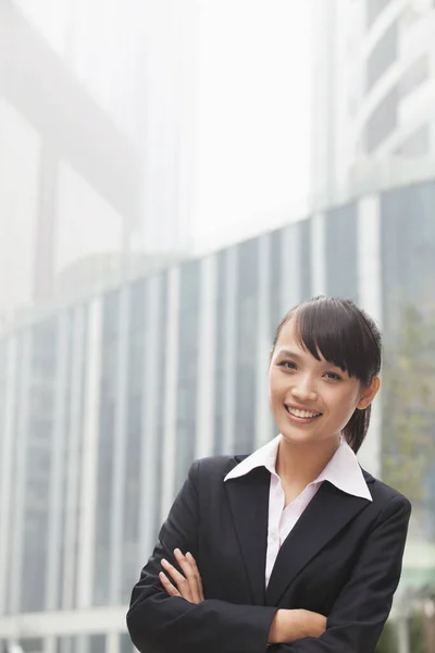 Smiling Chinese businesswoman with arms crossed