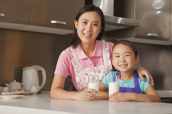 Chinese mother and daughter drinking milk