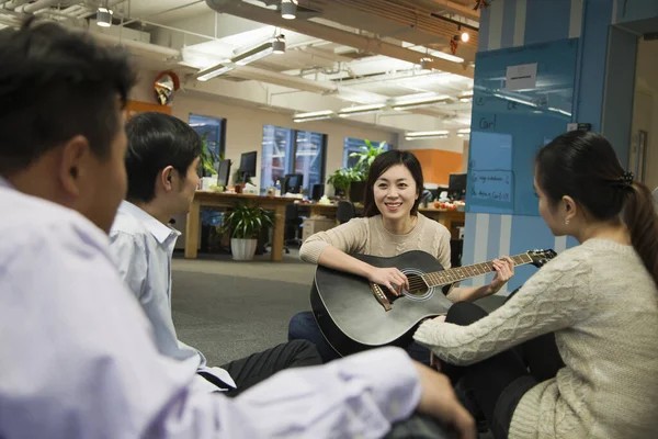 Chinese business people relaxing in office