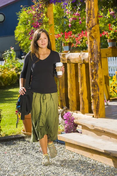 Alaskan woman walking with coffee