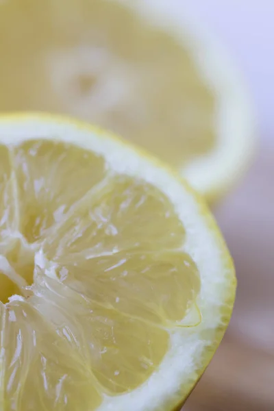 半分にスライスされるレモンのクローズアップ 垂直方向 — ストック写真