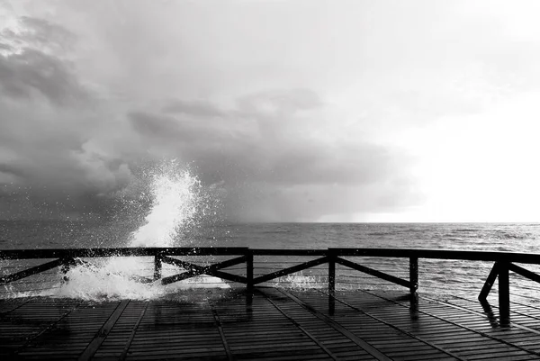 木製タラップで海のしぶきの黒と白の写真 — ストック写真