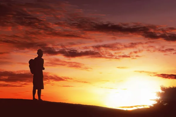 带背包的轮廓远足男子站在山顶上欣赏日落 — 图库照片
