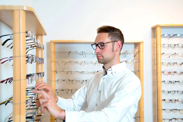 Obchodě Optiky Mladý Muž Vybírá Nové Brýle — Stock fotografie
