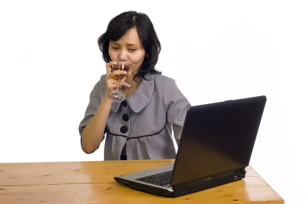 美しいアジアのビジネス女性は彼女のコンピュータの前でワインで彼女の成功を祝う — ストック写真