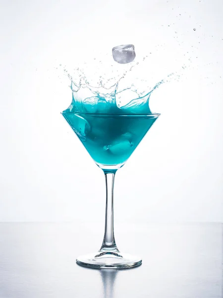 Coquetel Azul Vidro Martini Com Cubo Gelo Salpicando Líquido Contra — Fotografia de Stock