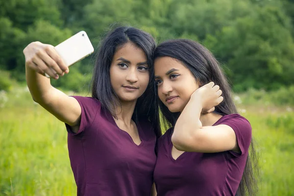 twins with mobile make a selfie