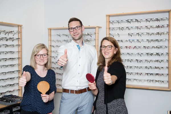 Optician Shop Two Women One Man Thumb Selecting New Glasses — Stock Photo, Image