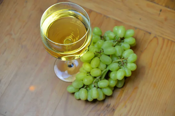 木のテーブルの上にブドウのある白ワイン — ストック写真