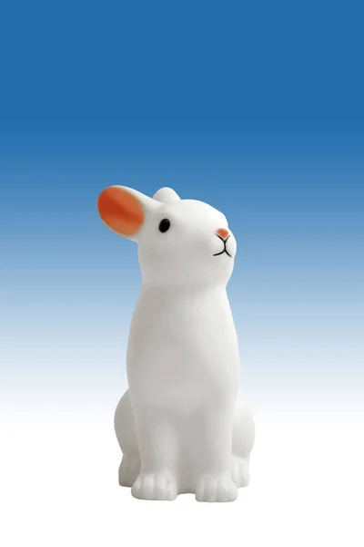 黒と白のグラデーションの背景に可愛い白いプラスチックのウサギ — ストック写真