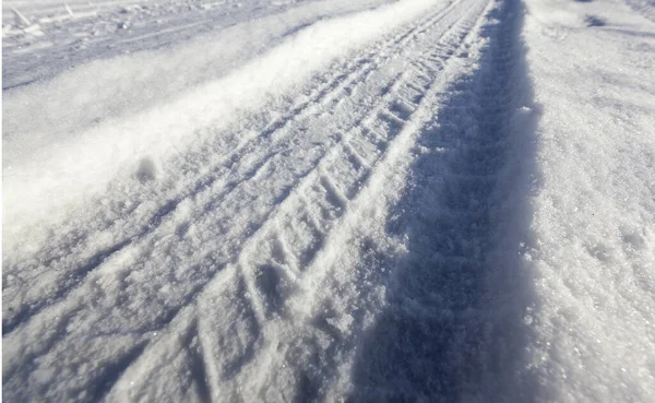 在降雪后被白雪覆盖的表面以一个角度拍摄的特写照片 干草从雪地里伸出来 实地深度小 — 图库照片