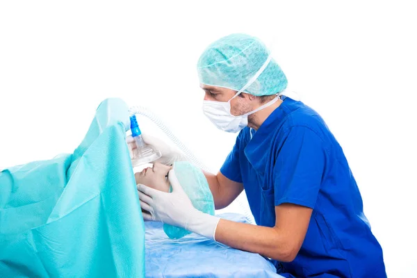 白い背景の前で酸素マスクと患者を持つ若い麻酔医は — ストック写真