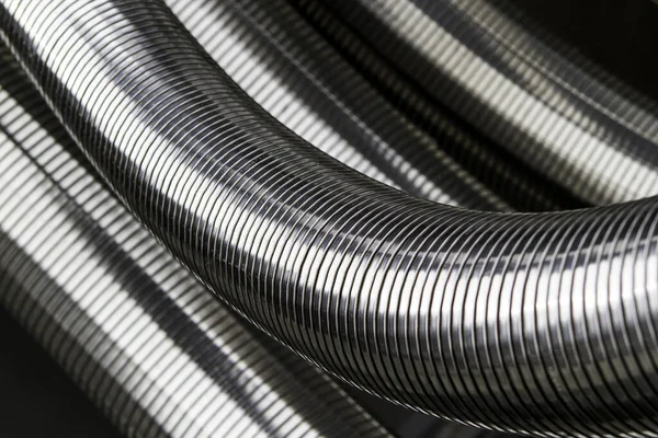 silver-colored metal hoses as grooved,flexible connectors.
