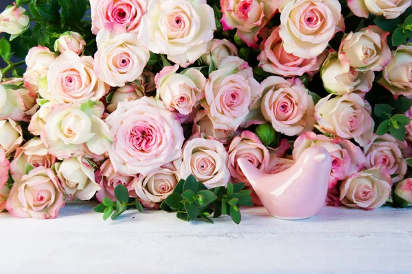 母の日とバレンタインデーのための白い木製のテーブルの上に多くの柔らかいピンクのバラ — ストック写真