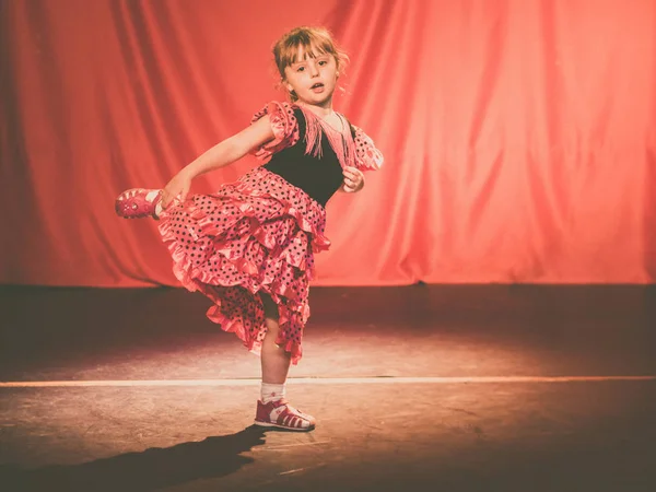 Little four years old girl dancing flamenco on stage in a theatre