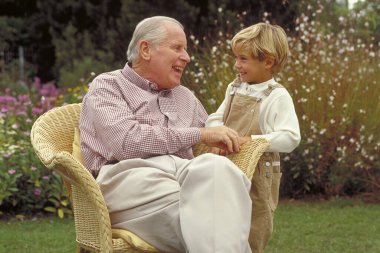 grandfather and grandson in a garden in park clipart