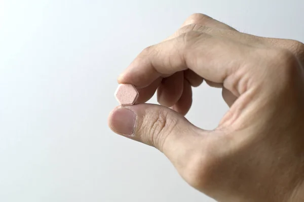 Hombre Tiene Una Píldora Mano Sobre Fondo Blanco —  Fotos de Stock