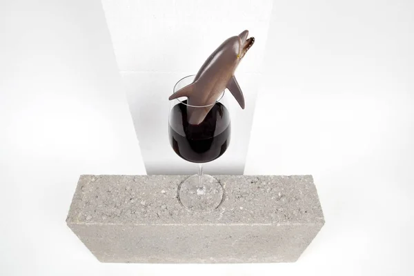 Ein Delphin Plastikspielzeug Einem Glas Rotwein Minimal Witzige Und Skurrile — Stockfoto