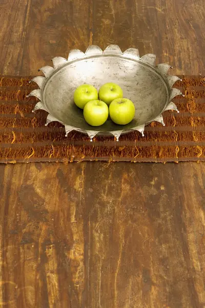 High angle view of four apples in a bowl at a dining table