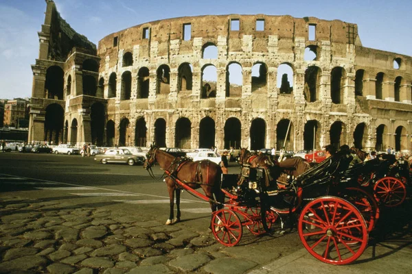 Horse drawn carriage in front of a colosseum, Rome, Italy