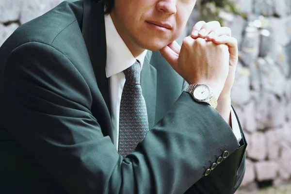 Close-up of a businessman with his hands clasped