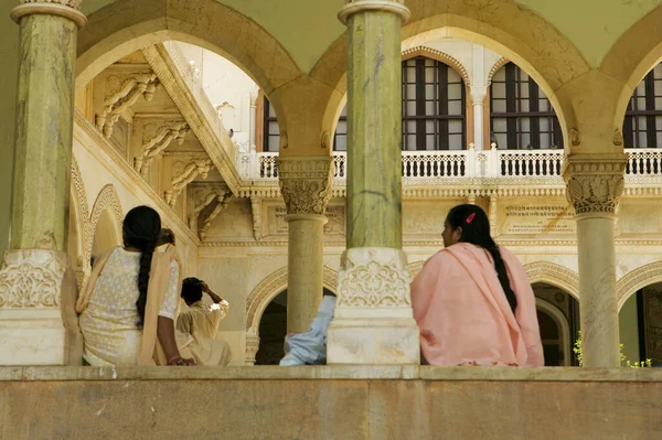 Low angle view of two women sitting inside a museum, Government Central Museum, Jaipur, Rajasthan, India