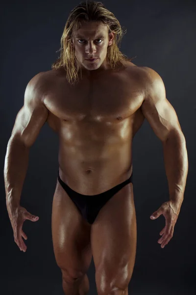 handsome muscular man with naked torso posing in studio