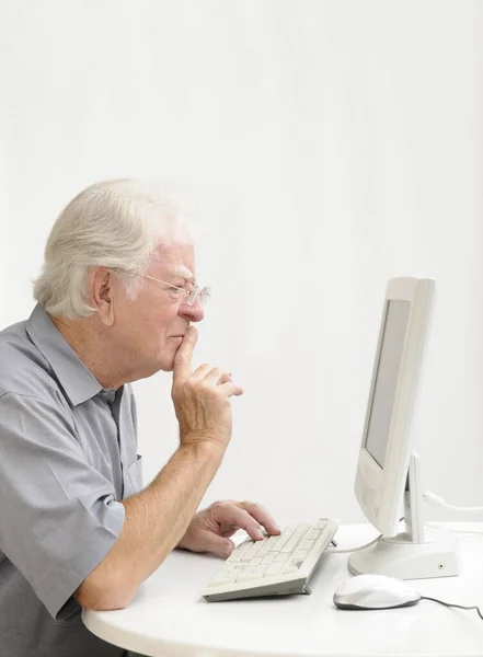 在家里从事计算机工作的老年人 — 图库照片