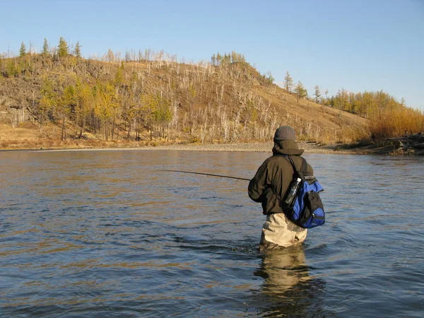 河岸上背着背包的渔夫 — 图库照片