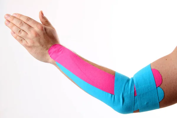Mão Segurando Uma Bandagem Rosa Fundo Branco — Fotografia de Stock