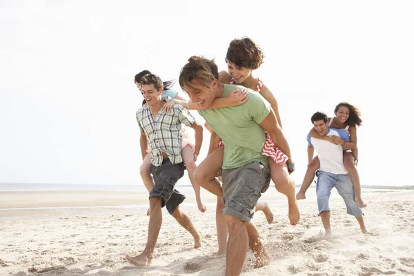 Grupa Przyjaciół Biegnących Wzdłuż Plaży Razem — Zdjęcie stockowe