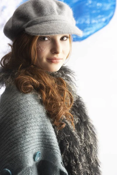 Fashionable Teenage Girl Wearing Cap And Knitwear In Studio