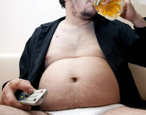 Uomo Sovrappeso Seduto Sul Divano Con Una Birra — Foto Stock