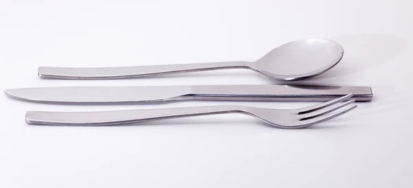 刀叉和勺子从现代不锈钢设计中分离出来 与白色和反光隔离 — 图库照片