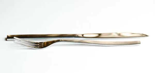 刀叉从现代不锈钢设计中分离出来 与白色和反光的褐色金光隔离 — 图库照片