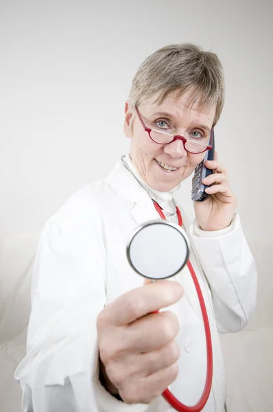 Ein Älterer Arzt Mit Brille Stethoskop Und Schnurlostelefon — Stockfoto