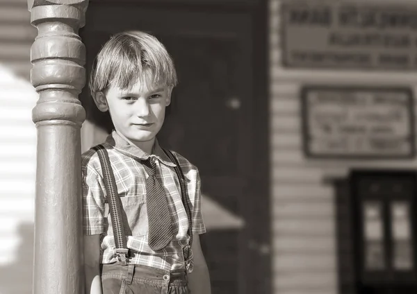 銀ゼラチン黒と白のネクタイとブレースの少年の古い店の前に立つ ロイヤリティフリーのストック画像