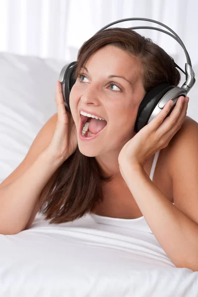 Junge Frau Mit Kopfhörern Singt Auf Weißem Sofa — Stockfoto