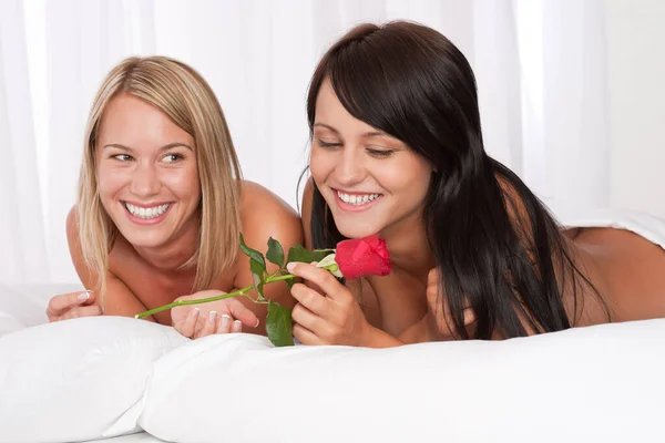 Dwie Młode Uśmiechnięte Kobiety Nagie Łóżku Czerwoną Różą — Zdjęcie stockowe