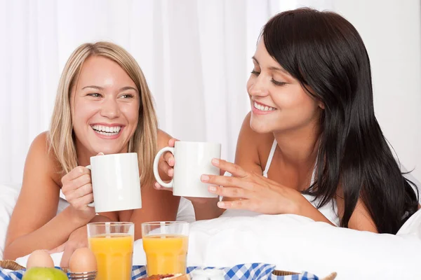 Twee Vrouwen Die Thuis Ontbijten Een Wit Bed Koffie Drinken — Stockfoto