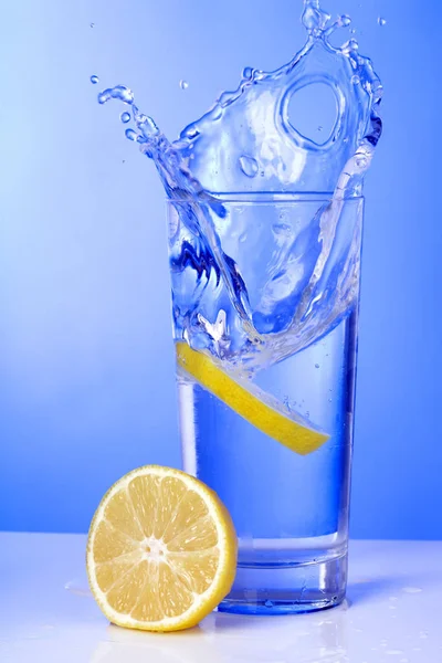 Glas Vatten Med Isbitar Blå Bakgrund — Stockfoto