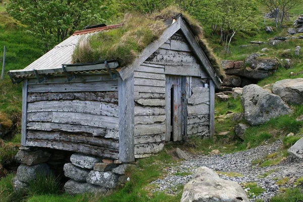 山の麓の小川の岩場にある木造小屋です — ストック写真